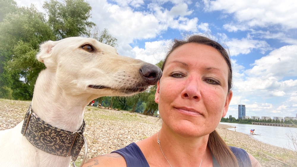 Désirée Scheller mit ihrem Windhund am Rhein
